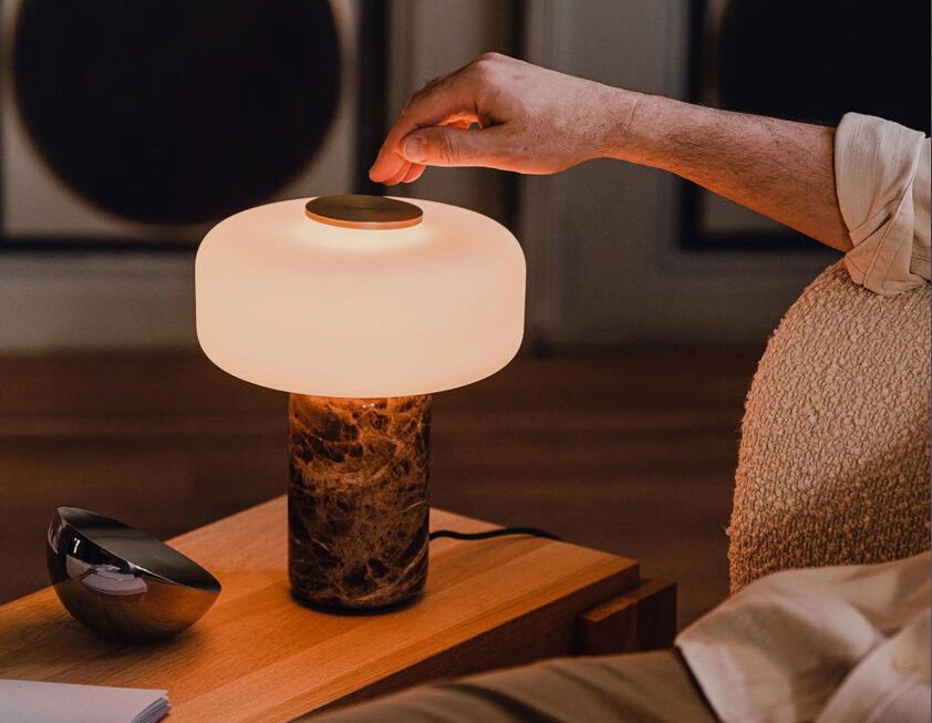 Fonte Table Lamp - Unique Composition of Marble Base and a Frosted Glass Shade 1 Fonte table lamp with marble base and frosted glass shade emitting warm ambient light on a wooden side table.